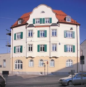 Wohn und Geschäftshaus in Ulm Dekorative Sprossenfenster mit Holzklappläden Im Erdgeschoss als Rundbogenfenster ausgebildet